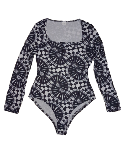 A long-sleeve bodysuit with a black and white geometric pattern featuring fan-like and checkerboard motifs, laid flat against a white background.